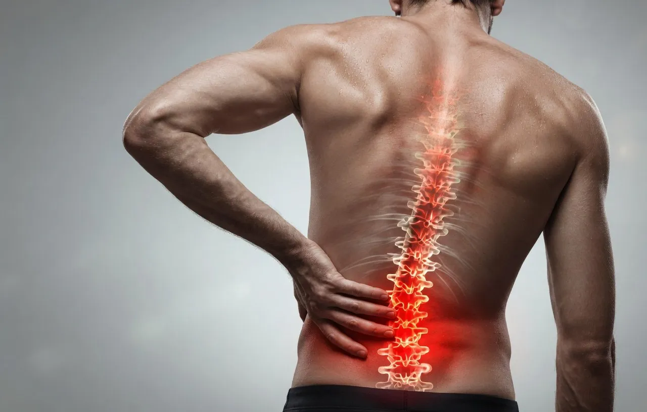 Man experiencing lower back pain — spine highlighted in red showing area of discomfort